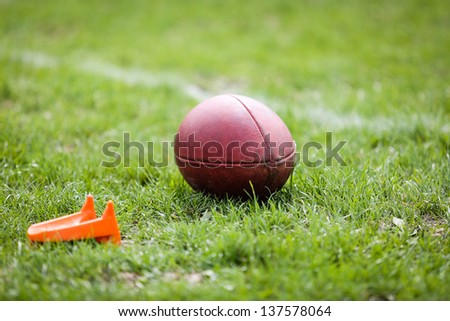 American football ball with football kicking tee