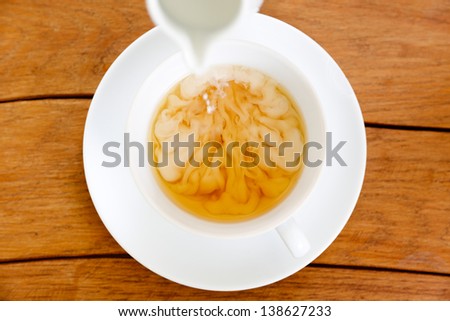 Cup of tea with pouring milk