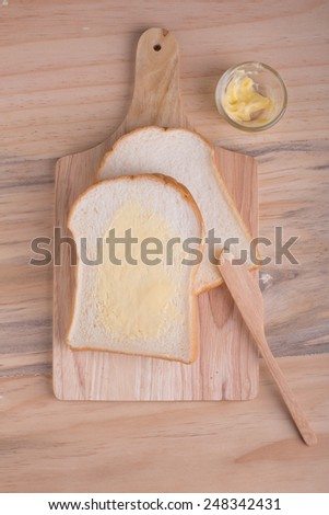 Top-view of slices bread with butter on wooden table