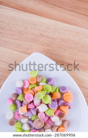 Aalaw candy, Thai candy dessert on white plate and wood table.