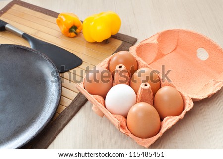 Eggs, fry pan, pepper, on a table ready for cooking breakfast