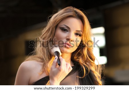 Attractive woman getting make up on. Photo of make up artist doing woman make up for her shot