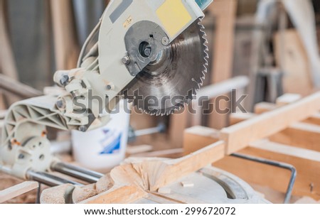 Carpenter Using Circular Saw. Carpenter use circular table electric saw cutting wood in workshop