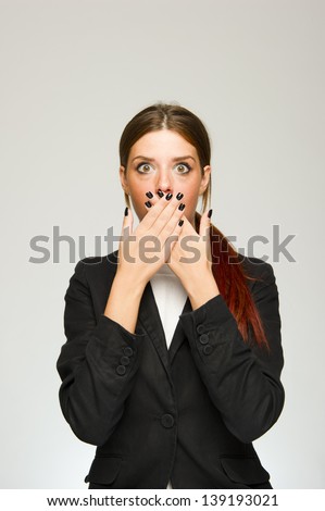Young surprised business woman mouth covered gesture on white background