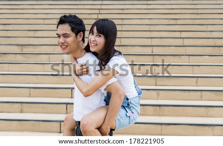 Lovely couple piggy back ride on the stairs