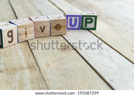 Wooden blocks are Give up word on wooden floor