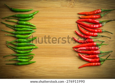 Green chilli pepper on Left side and Red chilli pepper on right side of chopping block