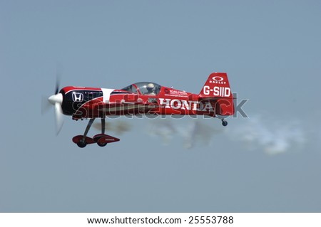 FAIRFORD, UK - JULY 16, 2005: Aerobatic plane smokes during a high speed pass during an air demonstration at the Royal International Air Tattoo on July 16, 2005 in Fairford, UK.