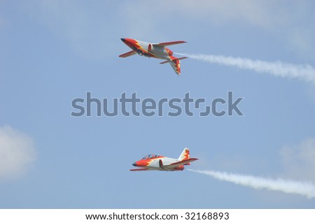 FAIRFORD, UK - JULY 16: Spanish Patrulla Ãguila solos perform a mirror pass during a display at the Royal International Air Tattoo on July 16, 2005 in Fairford, UK.