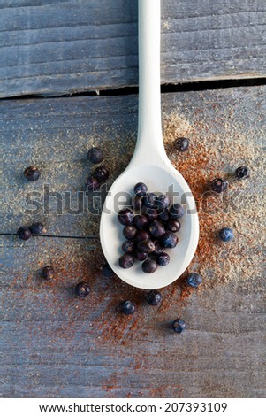 Juniper berries on wooden spoon