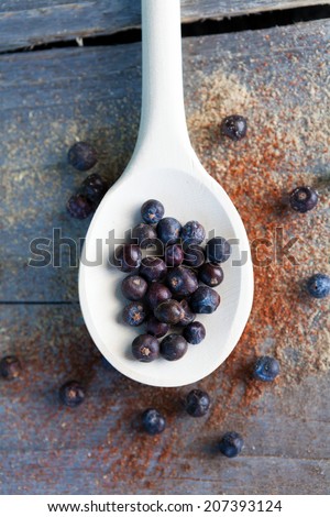 Juniper berries on wooden spoon