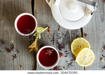 Red tea in white cups with lemon and teapot