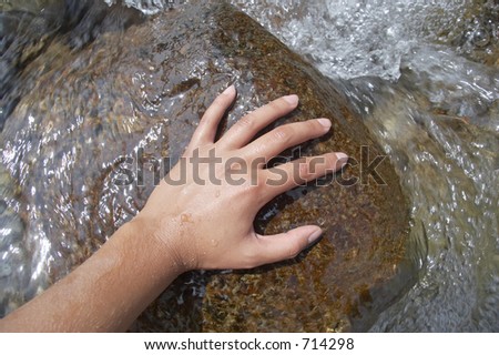 Girl\'s hand in the water of a mountain river, Alps mountains, Italy