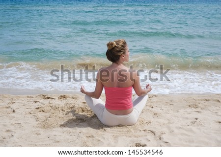 Girl doing yoga meditation on a beach in Sardinia