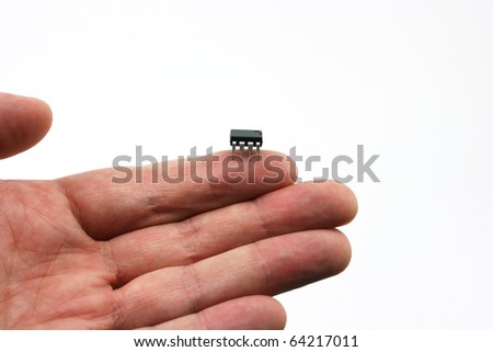 An isolated on hand on a white background holding a micro chip on the finger tip.