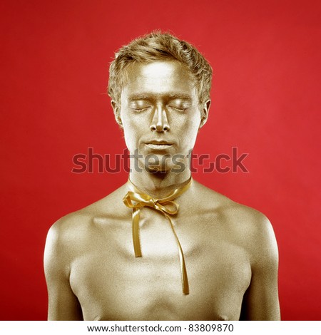 Fashion portrait of beautiful man with golden body art