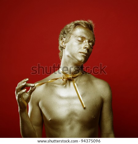 Fashion portrait of golden beautiful man with ribbon. Happy holiday