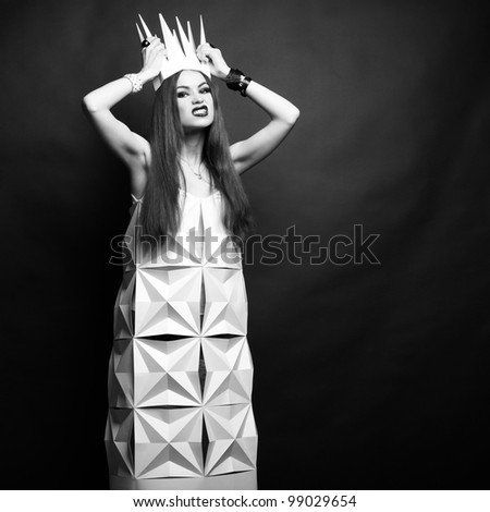 Beautiful woman in geometrical dress in crown. Fashion black and white portrait of queen.