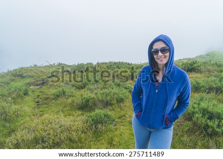 Woman standing on top of the mountains with fog and clouds in Brazil.