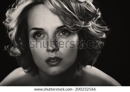 Black and white portrait of young beautiful woman with blond curly hair. studio photoshoot