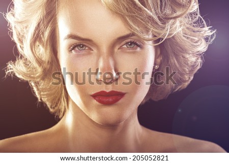 glamour fashion shine portrait of beautiful curly woman in rays of disco light