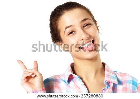 Fun Emotion Girl Sticking Out Tongue And Victory Gesture. Bright Studio Photoshoot
