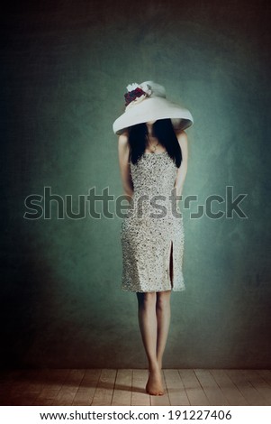 Beautiful girl in a hat stands barefoot on tiptoes can not see the face