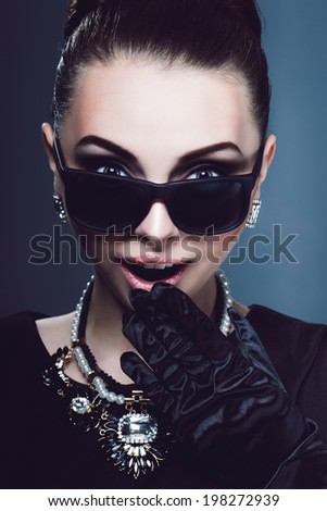 Portrait rich young girl with surprise and will hand dezhit mouth glasses or jewelery on the neck . Studio photo.Lovely woman retro portrait.