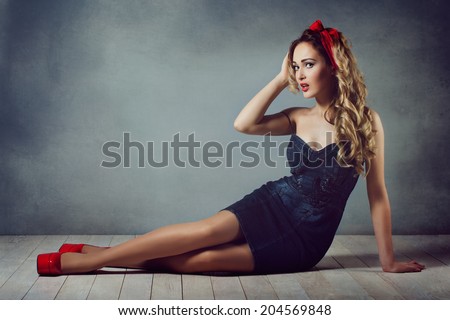 sexy blonde woman in jeans sundress and red shoes pin up girl retro woman sexy legs and a red capitium on his head crawling on the floor  sitting on the floor and straightens hair