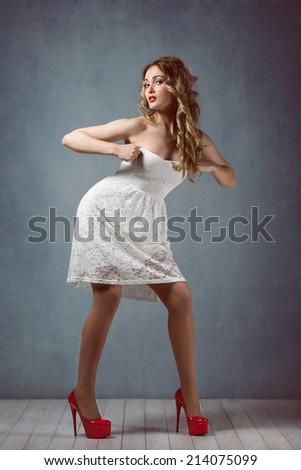 sexy beautiful blond girl with makeup in a white short dress with long legs in red high heels Pin up girl, retro woman, sexy legs surprised, scared