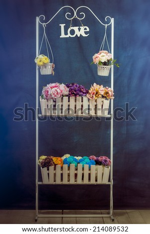 stand with flowers, flowers on the table wooden desk with artificial flowers, fence
