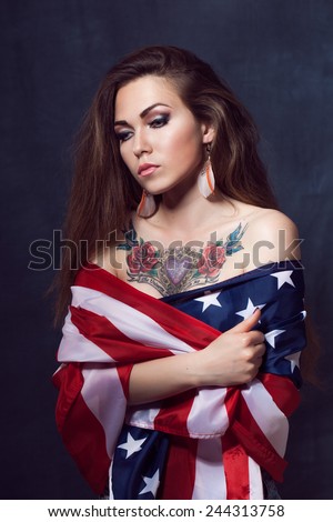 Young beautiful girl with long natural hair with a USA star flag flag with makeup tattooed roses and heart Indian tattoo