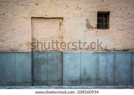 Walled door and grilled window on the facade of an old house