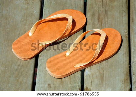 orange summer sandals on wood background