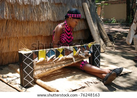LESEDI VILLAGE, SOUTH AFRICA - JANUARY 1:  Portrait of African Zulu woman wearing traditional handmade costume, weave straw carpet on January 01, 2008 in Lesedi African  Cultural village, South Africa