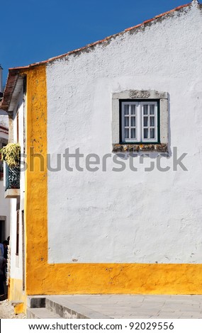 Old european house with white wall and window in sunny day(Obidos, Portugal)