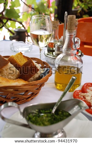 Dinner in outdoor italian restaurant. Olive oil, wine, appetizer, sauce in traditional mediterranean style. Selective focus.