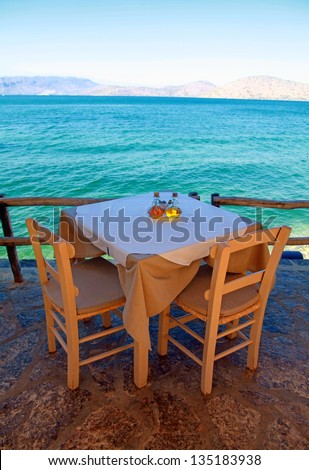 Table And Rural Chairs In Greek Outdoor Restaurant With Turquoise