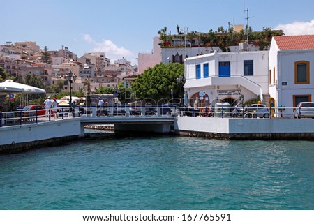 AGIOS NIKOLAOS, GREECE - JULY 18: Cityview with outdoor greek taverns and bridge at July 18,2012 in small lagoon Lake Voulismeni of Agios Nikolaos, Crete, Greece.