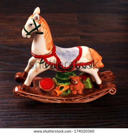 Vintage ceramic toy horse (christmas decoration also) on wood background.