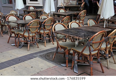 Outdoor french traditional cafe with old wood tables and wicker chairs in Old Town of Nice, French Riviera, France