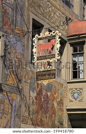 STEIN AM RHEIN, SWITZERLAND - MAY 05, 2013: Old beautiful fresco and signboard of restaurant on medieval building in Stein am Rhein, Switzerland