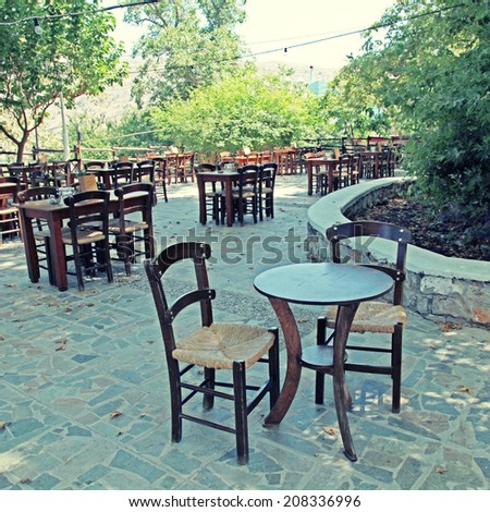 Tables and chairs of rural outdoor cafe, Crete, Greece. instagram effect, square image