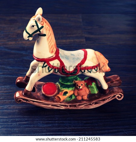 Vintage ceramic toy horse (christmas decoration also) on wood background, instagram effect