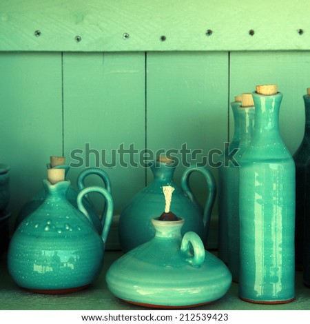 turquoise glazed ceramic pitchers in green shelf , Crete , Greece, instagram effect, square image