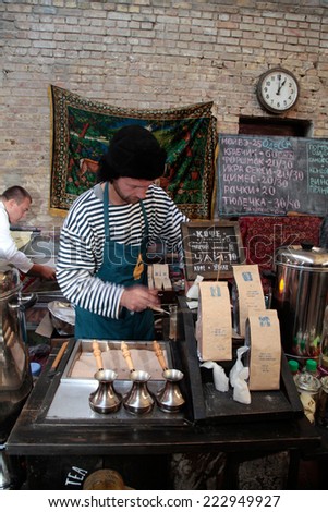 KIEV, UKRAINE - OCTOBER 11, 2014: Unidentified people cook and trades turkish coffee in copper pot with hot sand on food stall in Street Food Festival in Kiev, Ukraine.
