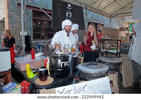 KIEV, UKRAINE - OCTOBER 11, 2014: Unidentified people cook and trades hot dog on food stall in Street Food Festival in Kiev, Ukraine.