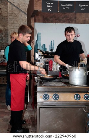 KIEV, UKRAINE - OCTOBER 11, 2014: Unidentified people cook and trades asian dishes on food stall in Street Food Festival in Kiev, Ukraine.
