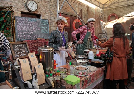 KIEV, UKRAINE - OCTOBER 11, 2014: Unidentified people cook and trades traditional dishes of Odessa restaurant on food stall and giving away TV interview in Street Food Festival in Kiev, Ukraine.