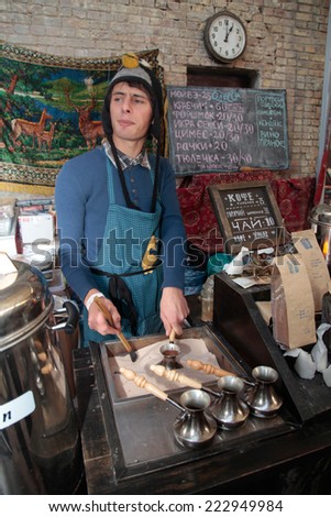 KIEV, UKRAINE - OCTOBER 11, 2014: Unidentified people cook and trades turkish coffee in copper pot with hot sand on food stall in Street Food Festival in Kiev, Ukraine.